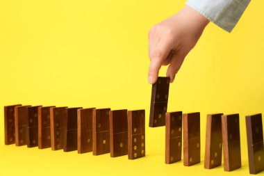 Kadın sarı arka planda domino taşından iniyor