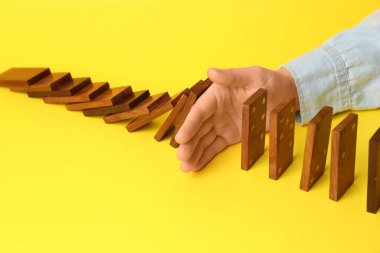 Sarı arka planda domino etkisini durduran kadın, yakın plan