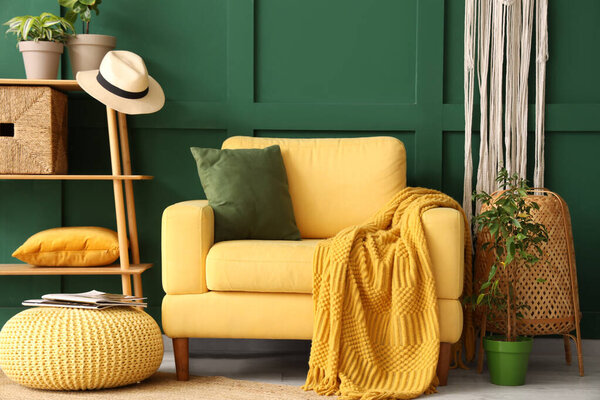 Interior of stylish living room with yellow armchair, pouf and shelf unit
