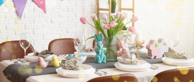 Paskalya yemeği için güzel bir masa. Evde taze çiçekler ve tavşanlar var.