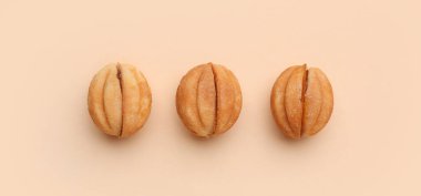 Tatlı ceviz şekilli kurabiyeler, bej arka planda kaynamış konsantre süt, üst manzara.