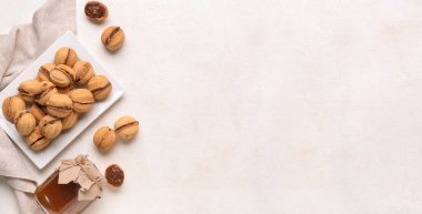 Kaynamış yoğunlaştırılmış sütle kaplı tatlı ceviz şekilli kurabiye tabağı. Arka planda metin ve üst görünüm için boşluk var.