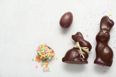 Çikolatalı Paskalya yumurtaları ve beyaz arka planda tavşanlar.