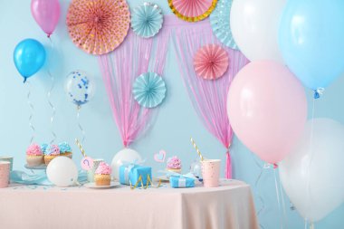 Masanın üzerinde mavi arka planda hediye kutuları ve süslemeleri olan lezzetli kekler. Cinsiyet ortaya çıkan parti kavramı