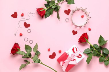 Kadın aksesuarlarından yapılmış çerçeve, hediye kutusu ve pembe arka planda gül çiçekleri.