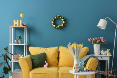 Paskalya için dekore edilmiş oturma odası. Kanepe ve vazolarla süslenmiş.