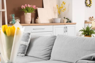 Paskalya için dekore edilmiş odanın içi vazoda tezgah ve lalelerle süslenmiş.