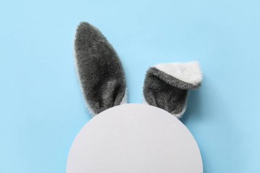 Yaratıcı kompozisyon. Mavi arka planda tavşan kulağı var. Paskalya kutlaması