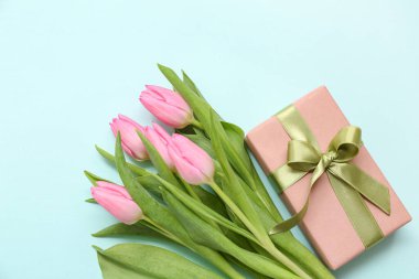 Hediye kutusu ve mavi arka planda güzel laleler. Uluslararası Kadınlar Günü