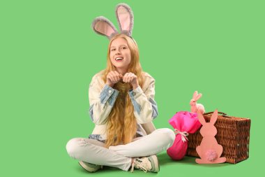 Yeşil arka planda Paskalyayı kutlayan genç kız.