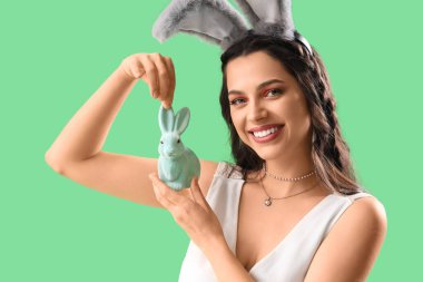 Tavşan kulaklı, yeşil arka planda Paskalya tavşanı olan güzel kadın, yakın plan.