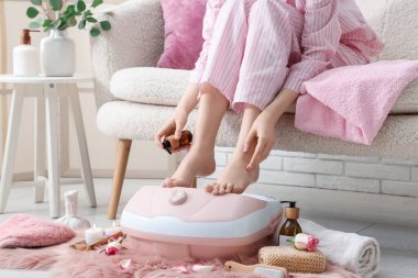 Masaj banyosu, spa aksesuarları ve kozmetik ürünleri olan bir kadın.