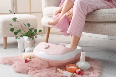 Masaj banyosu, spa malzemeleri ve okaliptüs dalları olan bir kadın.