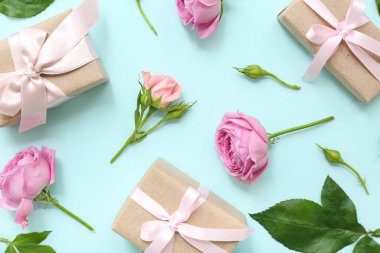 Cyan arka planda şakayık çiçekleri ile süslenmiş paket kutuları olan kompozisyon