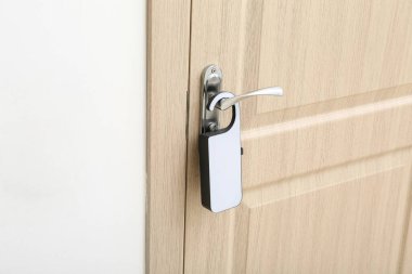 Otel odasında kapı askılı açık ahşap bir kapı.