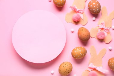 Paskalya yumurtaları, kağıt tavşanlar ve pembe arka planda pembe boş kart. Yakın çekim.