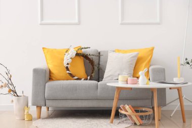 İçinde kanepe, masa ve Paskalya çelengi olan festival salonu.