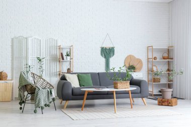 Bambu saplı ve kanepeli modern oturma odasının içi aydınlık.