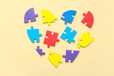 Açık sarı arkaplanda renk bulmacasından yapılmış bir kalp. Otistik bozukluk kavramı