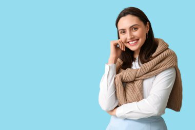 Mavi arka planda gülümseyen genç kadın