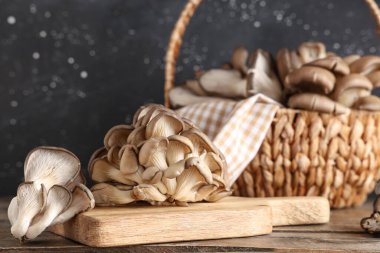 Tahta sepet ve ahşap masada taze istiridye mantarı.