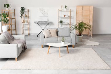 Oturma odasının içinde raflar, kanepeler ve kahve masası var.