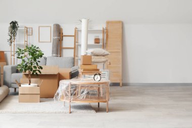 Çiçek, sehpa ve karton kutular taşınma gününde oturma odasında.