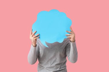 Pembe arka planda boş konuşma balonu olan genç bir adam.