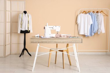 Terzinin dikiş makinesi, farklı malzemeler ve atölye mankeni.