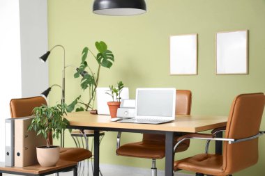 Laptopları toplantı için hazırlanmış modern ofisin içi.