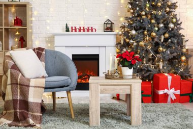 Koltuk ve kahve masası. Oturma odasının iç tarafında Noel çiçeği süsleri var.