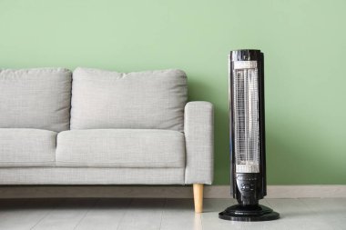 Modern elektrikli ısıtıcı ve gri kanepeli şık bir oturma odası.