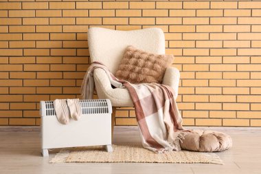 Modern konveksiyon ısıtıcısı ve rahat beyaz koltuğu olan şık bir oturma odası.