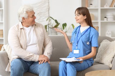 Evdeki kanepede olgun bir adamla çalışan kadın doktor.