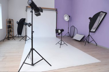 Profesyonel ışıklandırma ekipmanları ve beyaz arkaplanı olan fotoğraf stüdyosunun içi