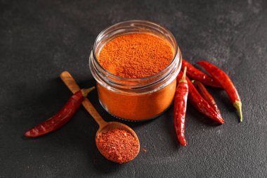 Kırmızı biberli kavanoz ve siyah arka planda biber.