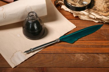 Kağıt çarşaf kalem ucu ve ahşap arka planda mürekkep.