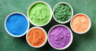 Yeşil arka planda parlak tozlu bir sürü kase, üst görünüm