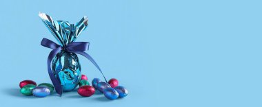 Açık mavi arkaplanda paskalya yumurtaları ve metin için yer var.