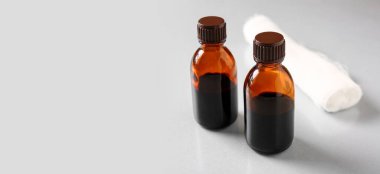 Gri arkaplanda iyot ve gazlı bez ruloları ve metin için yer var.