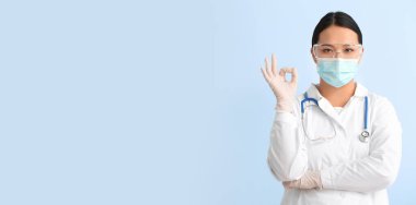 Kadın Asyalı doktorun portresi açık mavi arkaplanda metin için boşluk olduğunu gösteriyor