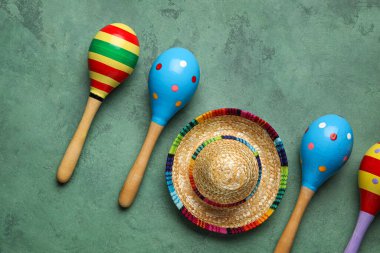 Yeşil arka planda şapkası olan Meksika marakaları