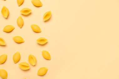 Sarı arkaplanda çiğ konchiglie makarna