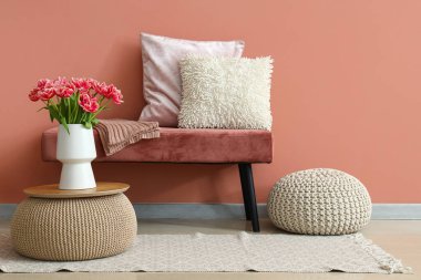 Şık bir odanın içinde yastıklı pembe bank.