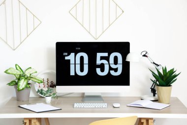 Işık ofisinde bilgisayar monitörü ve yapay tesisleri olan modern işyeri