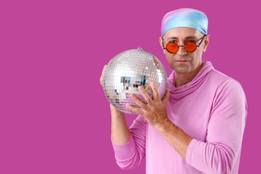 Mor arka planda disko topu olan havalı olgun bir adam.