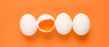 Turuncu arka planda çiğ tavuk yumurtası, üst manzara.