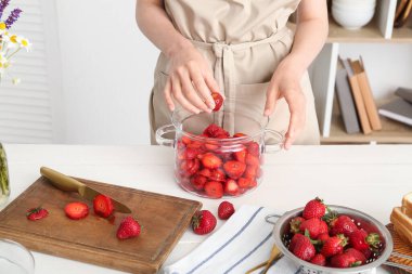 Mutfakta tatlı çilek reçeli hazırlayan kadın, yakın plan.