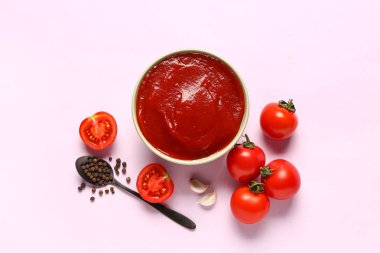 Domates ezmeli kase ve leylak arkaplanda taze sebzeler.