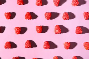 Pembe arka planda bir sürü taze ahududu